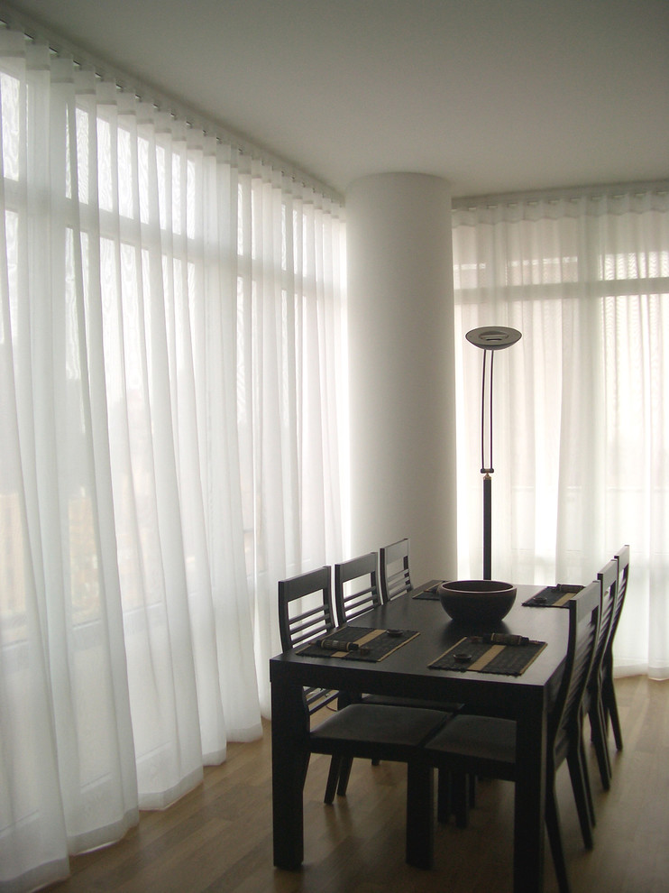 Immagine di una sala da pranzo moderna di medie dimensioni con pareti bianche e pavimento in legno massello medio