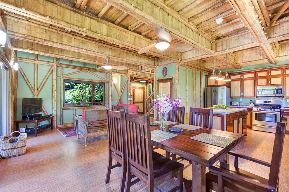 Esempio di una sala da pranzo aperta verso il soggiorno tropicale con pareti verdi e pavimento in bambù