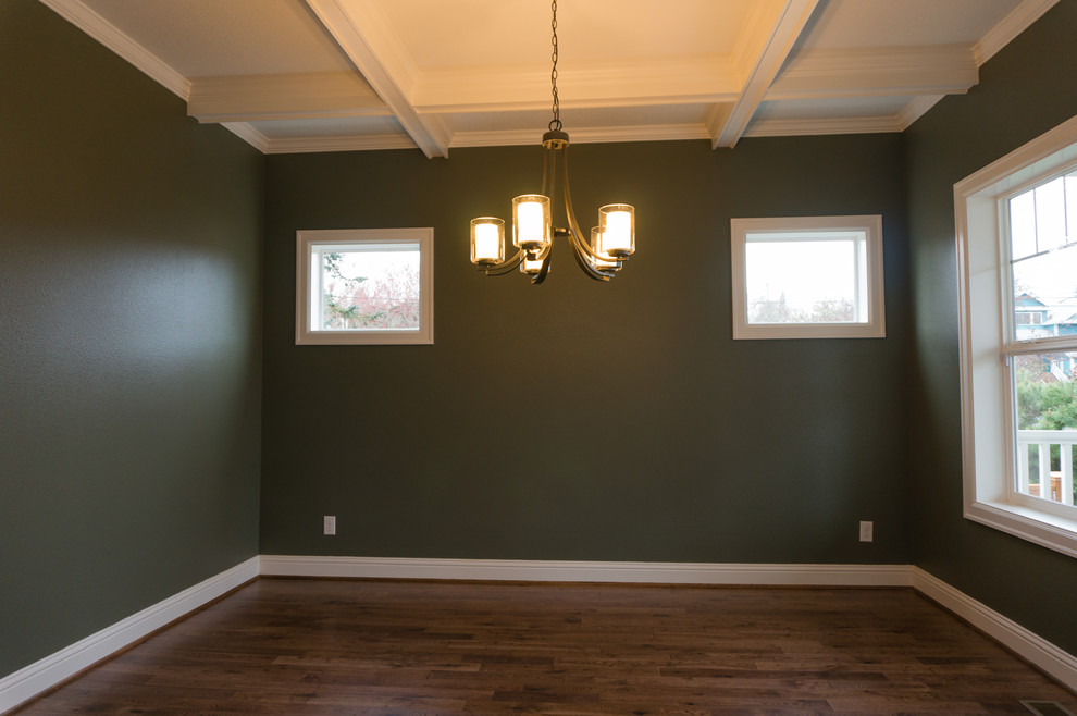 Idée de décoration pour une salle à manger craftsman fermée et de taille moyenne avec un mur vert, un sol en bois brun et aucune cheminée.