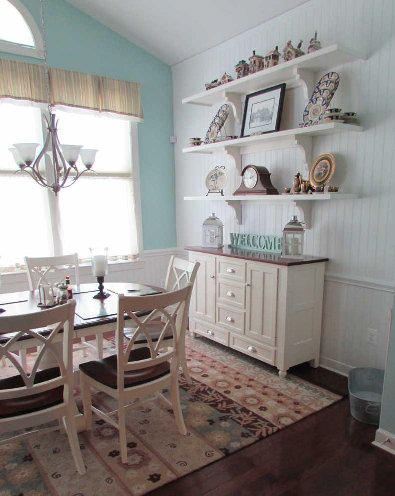 Cette image montre une salle à manger ouverte sur la cuisine traditionnelle de taille moyenne avec un mur blanc, parquet foncé, aucune cheminée, un sol marron, un plafond voûté et du lambris de bois.