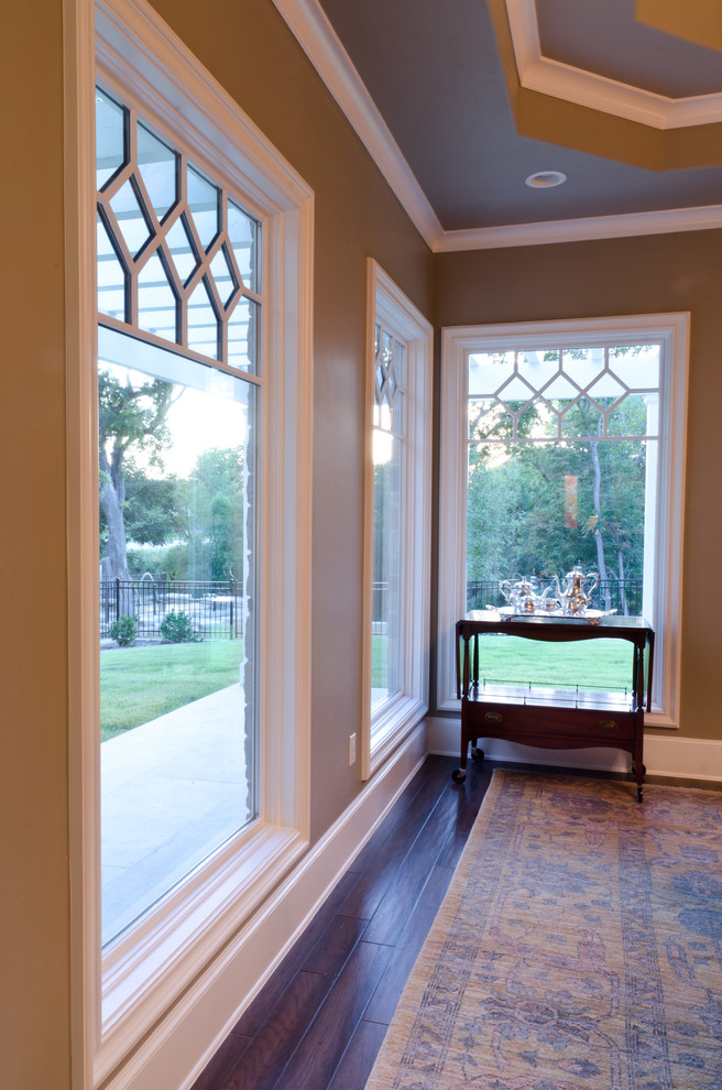 Large elegant medium tone wood floor enclosed dining room photo in Austin with beige walls