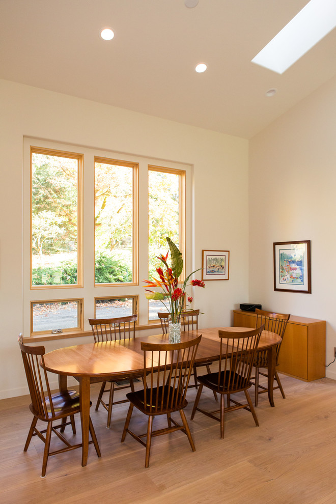 Ejemplo de comedor contemporáneo pequeño abierto con paredes blancas y suelo de madera clara