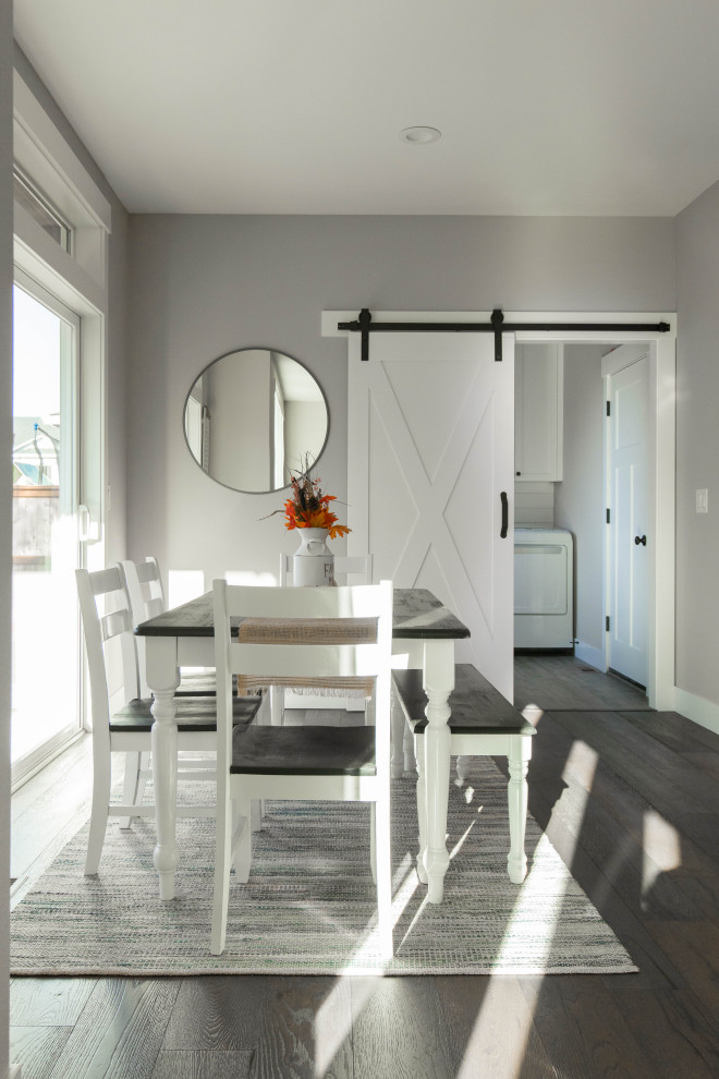Cette photo montre une grande salle à manger ouverte sur le salon craftsman avec un mur gris, parquet foncé et un sol marron.