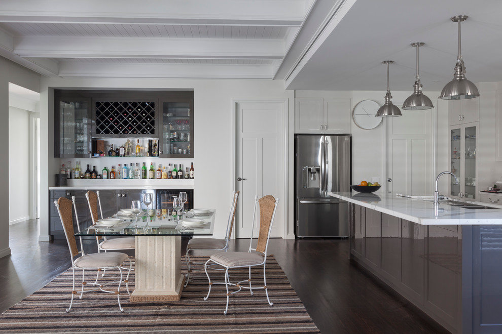 На фото: кухня-столовая в стиле неоклассика (современная классика) с белыми стенами и темным паркетным полом