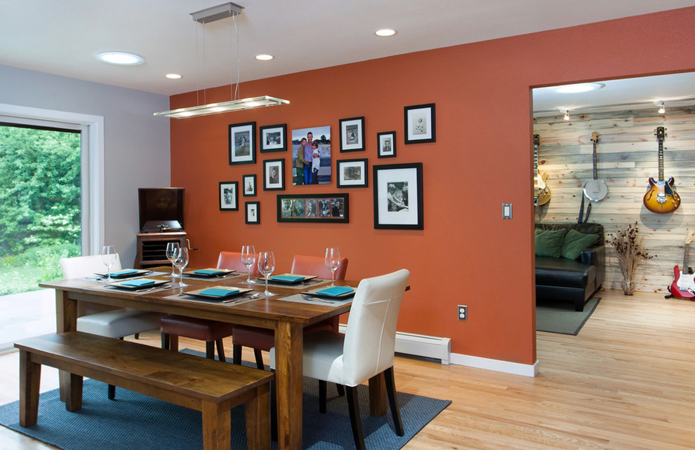 Cette image montre une salle à manger traditionnelle fermée et de taille moyenne avec un mur rouge, parquet clair, aucune cheminée et un sol beige.
