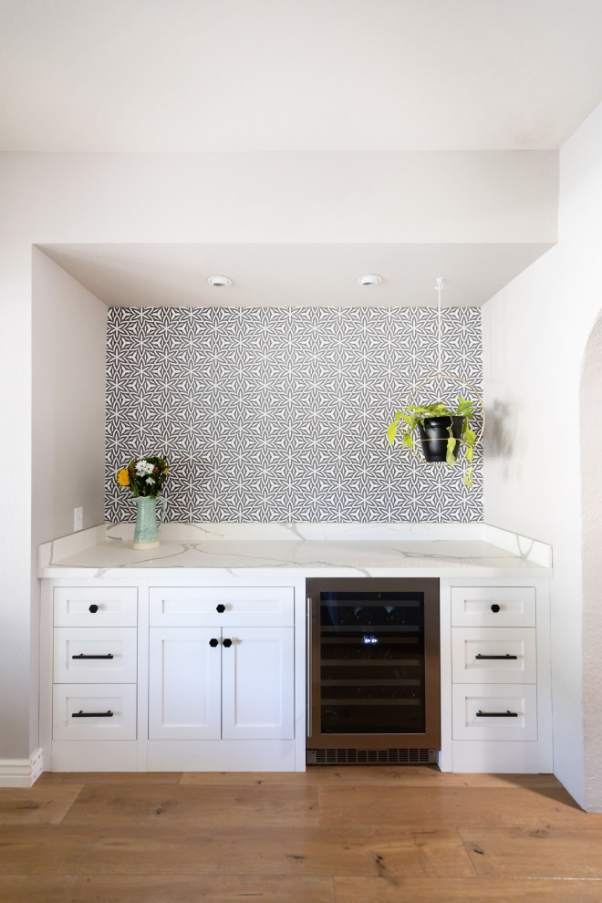 Idée de décoration pour une petite salle à manger ouverte sur la cuisine marine avec un mur blanc, parquet clair, un sol marron et du papier peint.