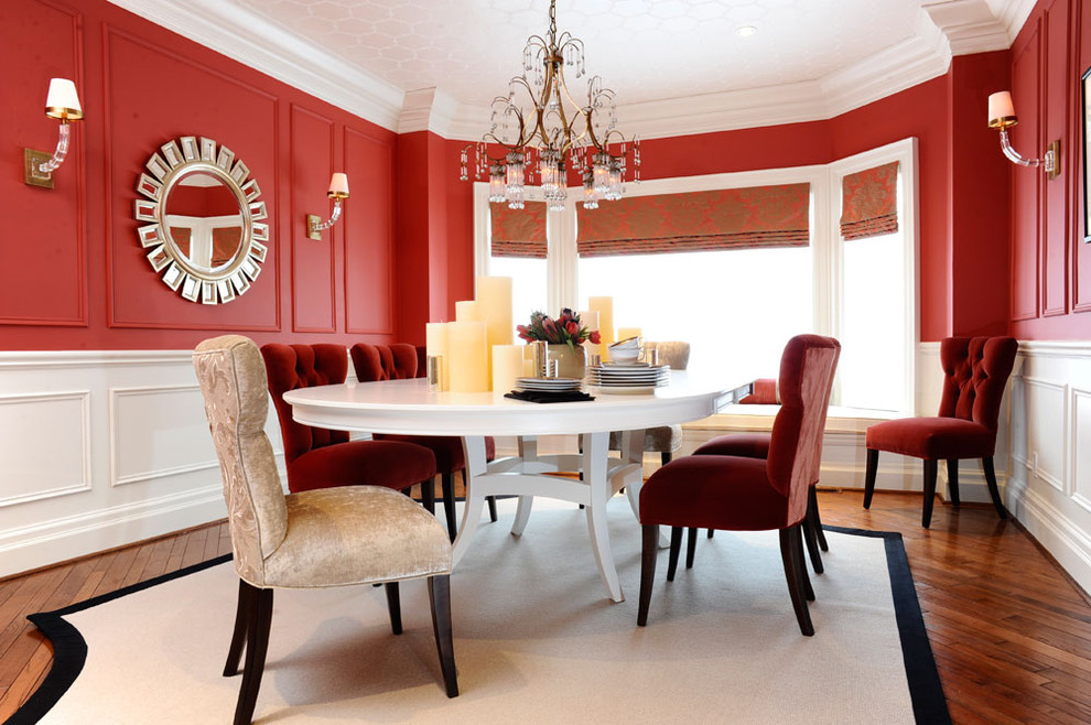 Diseño de comedor actual con paredes rojas y suelo de madera oscura