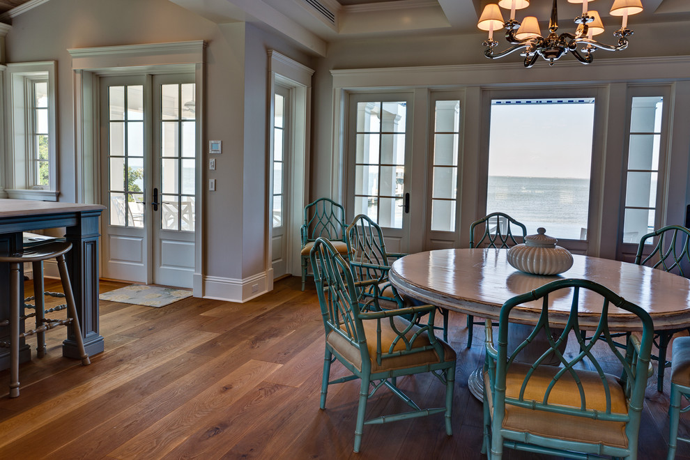 Exemple d'une salle à manger ouverte sur le salon craftsman de taille moyenne avec un sol en bois brun, un mur gris, aucune cheminée et un sol marron.