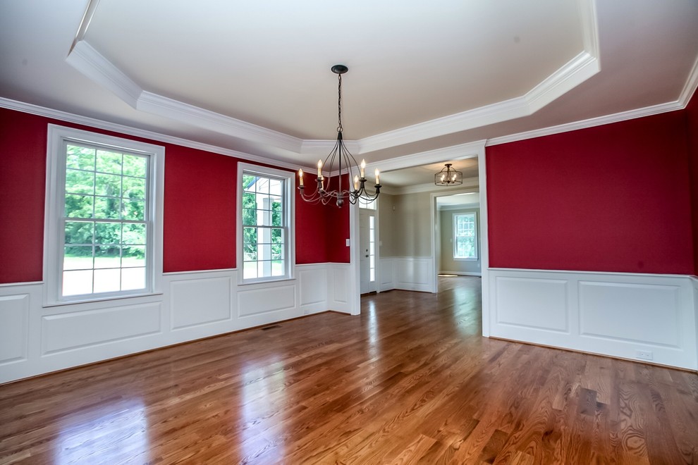 Foto di una grande sala da pranzo classica chiusa con pareti rosse e pavimento in legno massello medio
