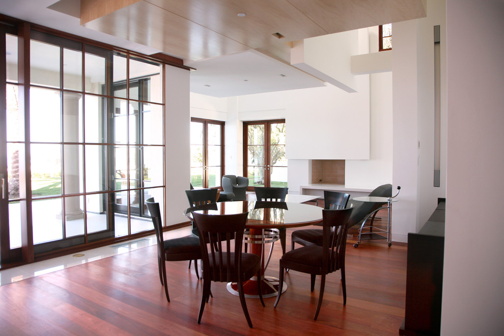 Ispirazione per una grande sala da pranzo aperta verso il soggiorno moderna con pareti bianche e pavimento in legno massello medio
