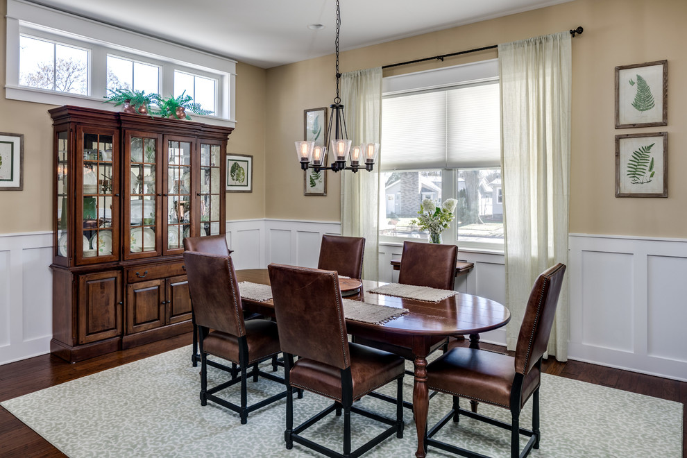 Immagine di una sala da pranzo classica con pareti beige, parquet scuro e pavimento marrone