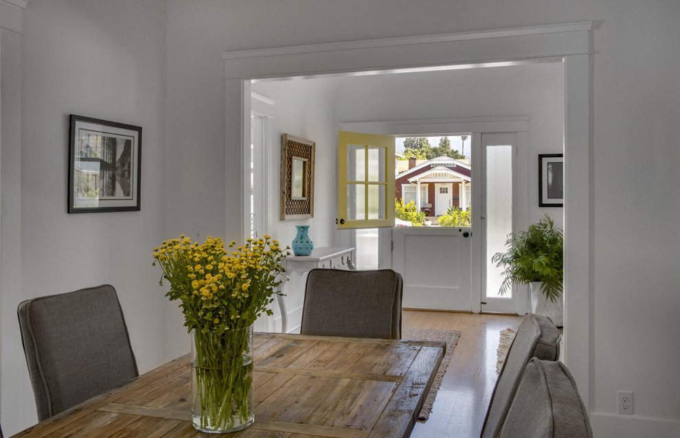 Cette photo montre une petite salle à manger ouverte sur le salon montagne avec un mur blanc, un sol en bois brun et aucune cheminée.