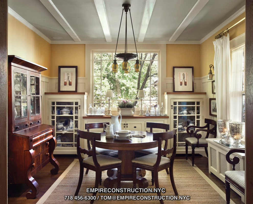 Esempio di una sala da pranzo aperta verso la cucina stile americano di medie dimensioni con pareti gialle, pavimento in legno massello medio e nessun camino