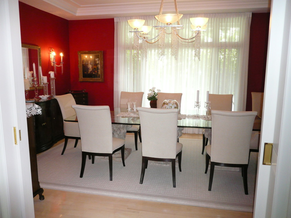 Immagine di una sala da pranzo classica chiusa e di medie dimensioni con pareti rosse, parquet chiaro e nessun camino