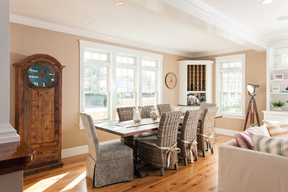 Immagine di una sala da pranzo aperta verso il soggiorno costiera di medie dimensioni con pareti beige e pavimento in legno massello medio