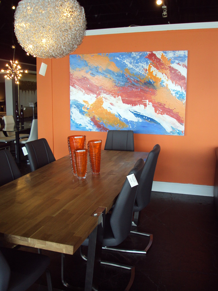 Modernes Esszimmer mit oranger Wandfarbe und Betonboden in Houston