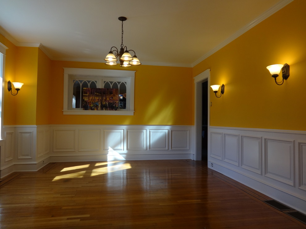 Стильный дизайн: большая отдельная столовая в классическом стиле с оранжевыми стенами, паркетным полом среднего тона и коричневым полом - последний тренд
