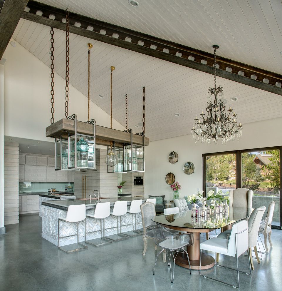 Cette image montre une grande salle à manger ouverte sur la cuisine design avec un mur blanc, sol en béton ciré et aucune cheminée.