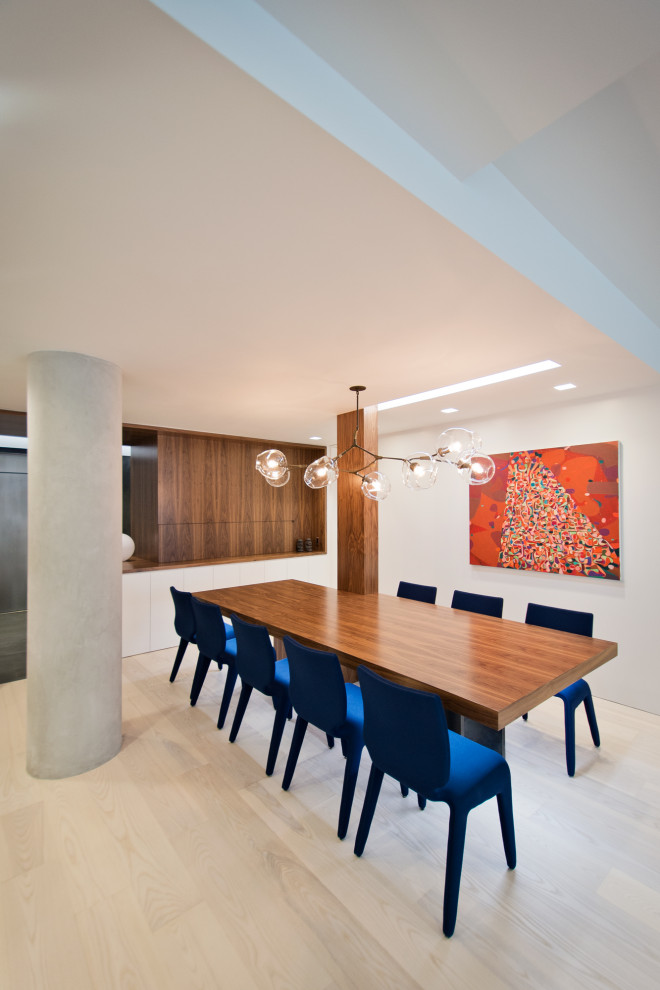 Large modern open plan dining room in New York with white walls, light hardwood flooring and beige floors.