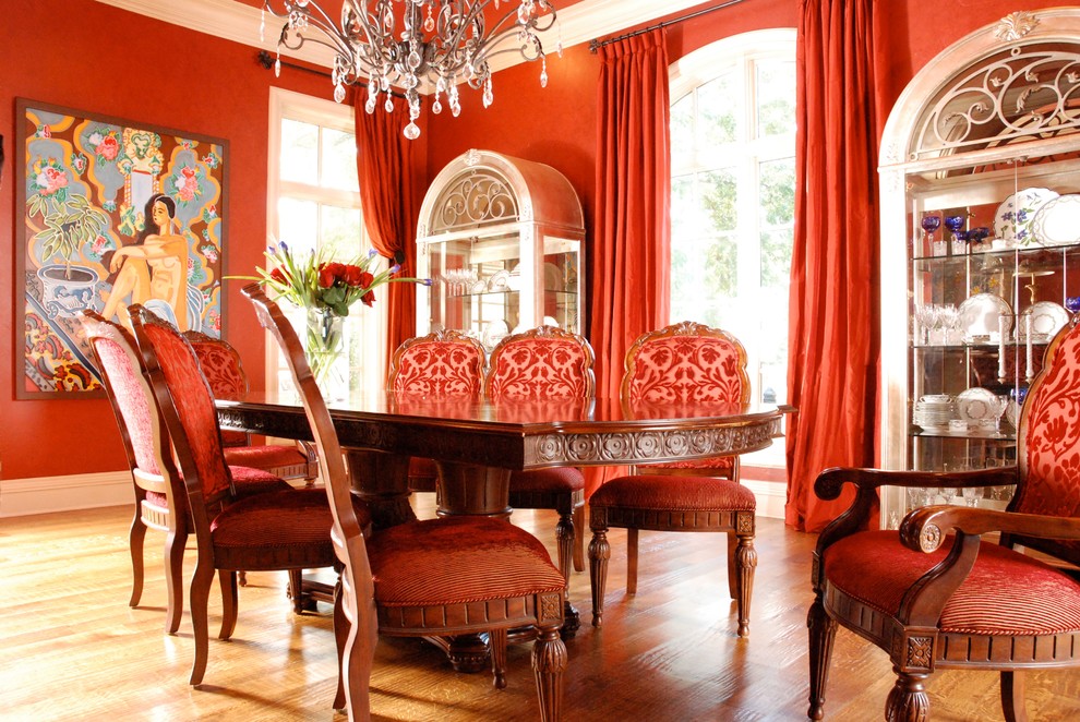 Ispirazione per una sala da pranzo aperta verso la cucina classica di medie dimensioni con pareti rosse e pavimento in legno massello medio