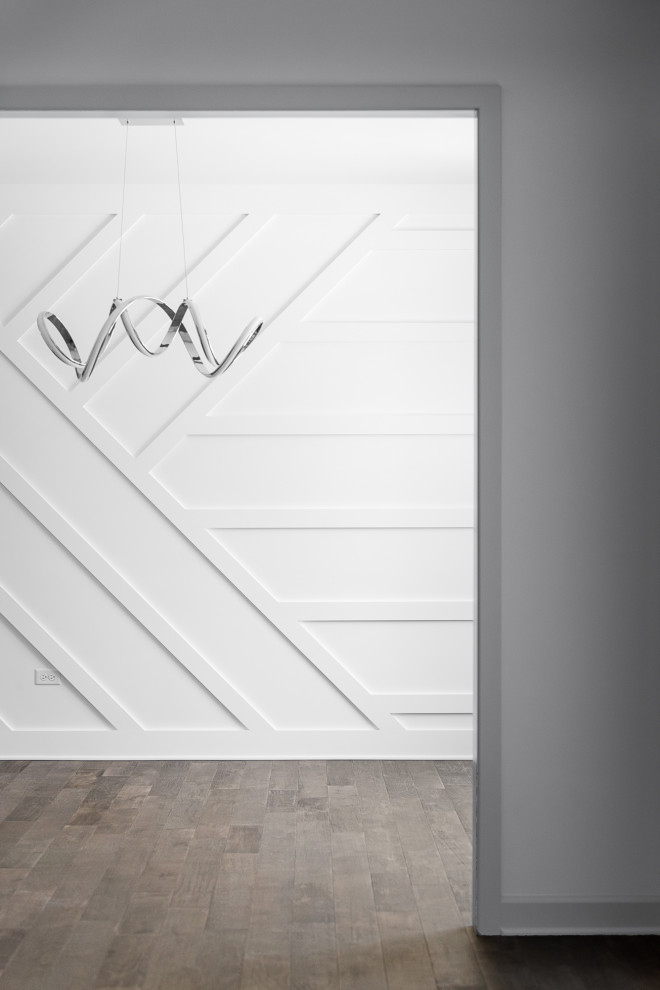 Ejemplo de comedor minimalista grande cerrado con paredes blancas, suelo de madera en tonos medios, suelo marrón y madera