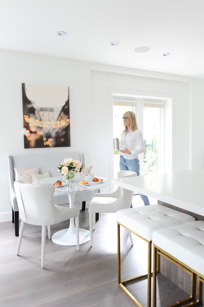Esempio di una piccola sala da pranzo aperta verso la cucina moderna con pareti bianche, pavimento in legno massello medio e nessun camino