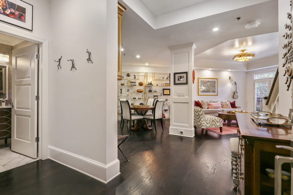 Exemple d'une petite salle à manger ouverte sur le salon éclectique avec un mur blanc, parquet foncé et un sol noir.