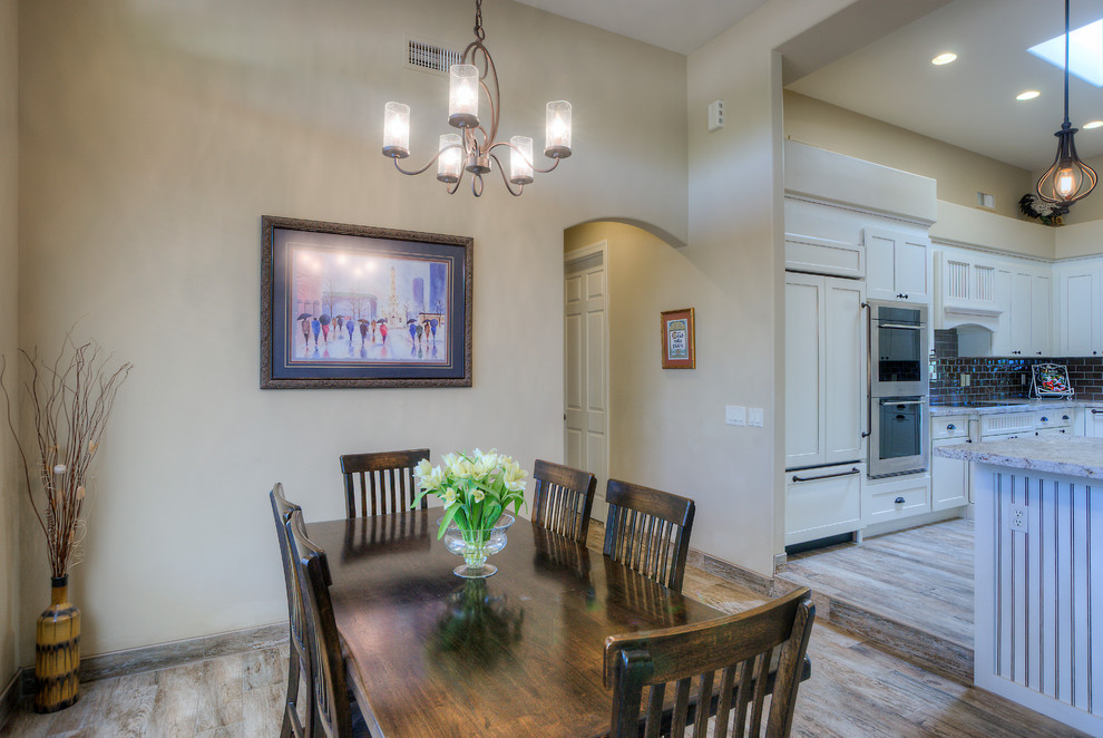 Immagine di una sala da pranzo aperta verso la cucina moderna di medie dimensioni con pareti beige e pavimento in legno massello medio