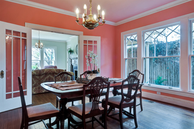 Idées déco pour une salle à manger craftsman avec un mur rose, un sol en bois brun et aucune cheminée.