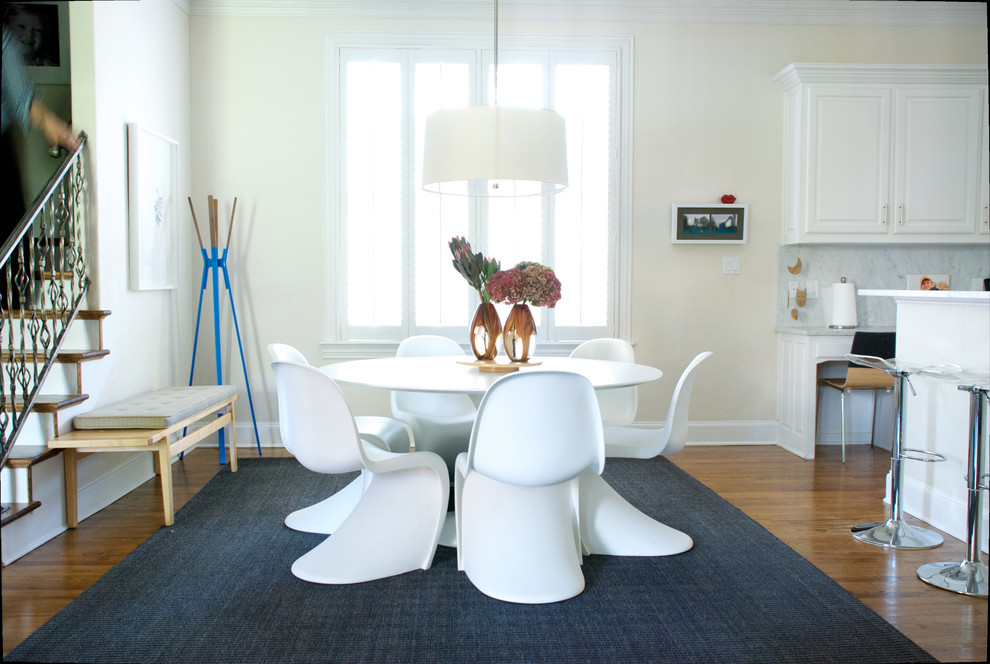 Esempio di una sala da pranzo design con pareti beige e pavimento in legno massello medio