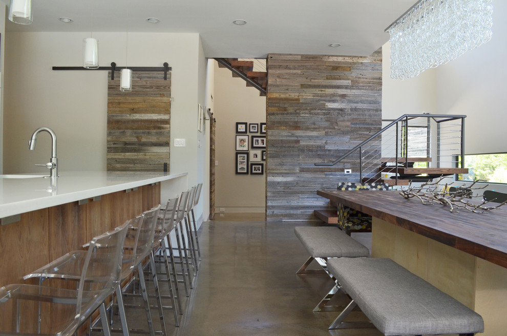Exemple d'une salle à manger ouverte sur la cuisine tendance avec un mur blanc, sol en béton ciré et aucune cheminée.