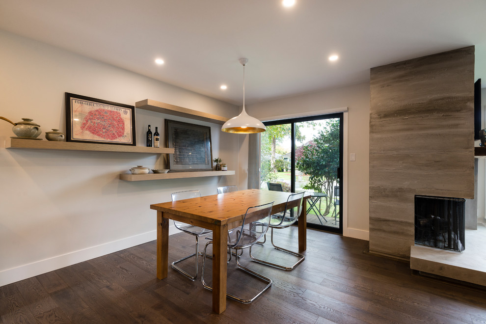 Idée de décoration pour une salle à manger ouverte sur le salon design de taille moyenne avec un mur gris et un sol en bois brun.