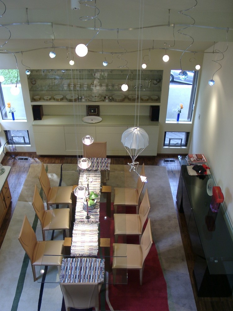 Cette photo montre une salle à manger éclectique avec un mur blanc et parquet foncé.