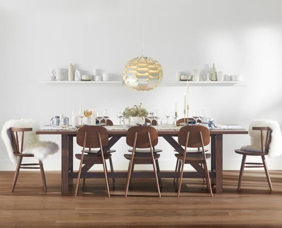 Idée de décoration pour une salle à manger ouverte sur le salon nordique de taille moyenne avec un mur blanc, un sol en bois brun, aucune cheminée et un sol marron.