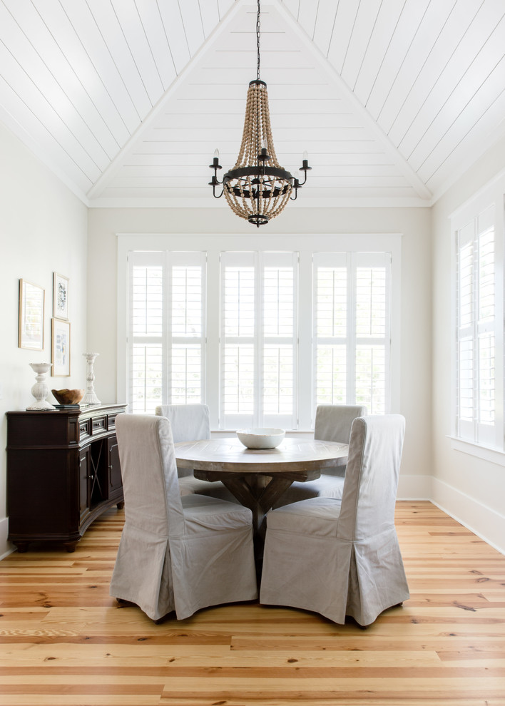 Foto di una sala da pranzo costiera chiusa e di medie dimensioni con pareti bianche, parquet chiaro e pavimento beige