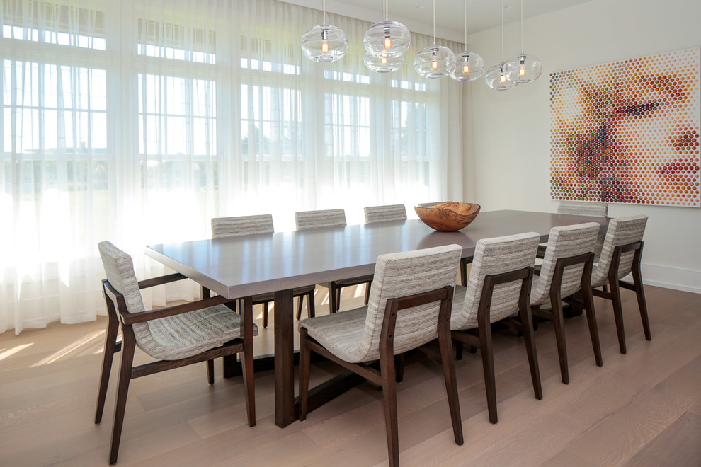 Ispirazione per una sala da pranzo aperta verso la cucina contemporanea di medie dimensioni con pareti bianche e pavimento in legno massello medio