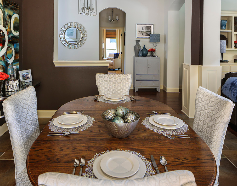 Immagine di una sala da pranzo aperta verso la cucina tradizionale di medie dimensioni con pareti marroni, pavimento in gres porcellanato e nessun camino
