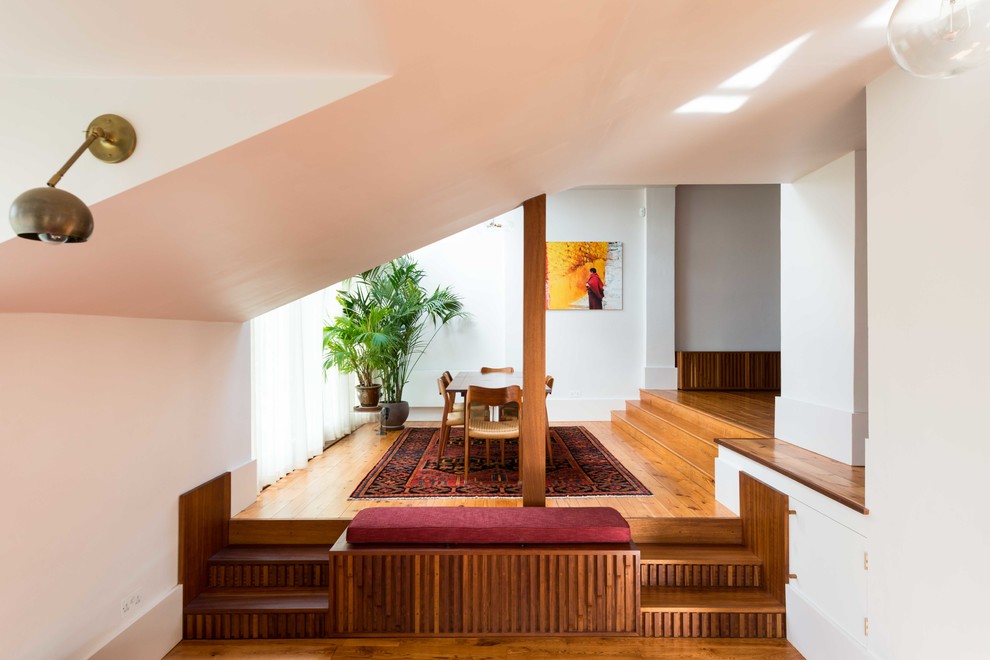 Immagine di una sala da pranzo etnica di medie dimensioni con pareti bianche, parquet chiaro e pavimento marrone