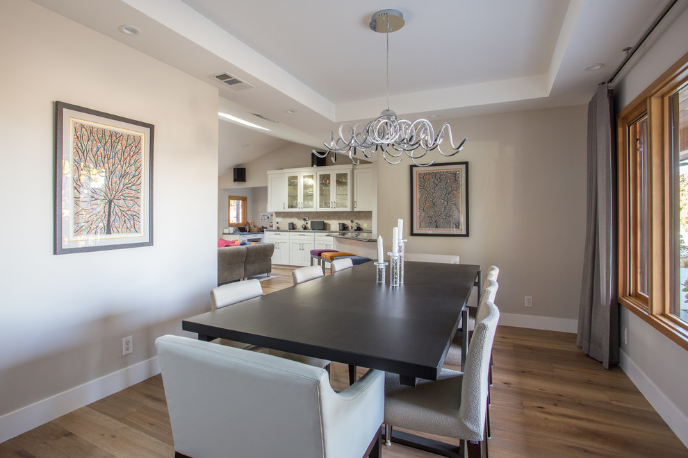 Inspiration pour une salle à manger ouverte sur la cuisine minimaliste de taille moyenne avec un mur gris et un sol marron.