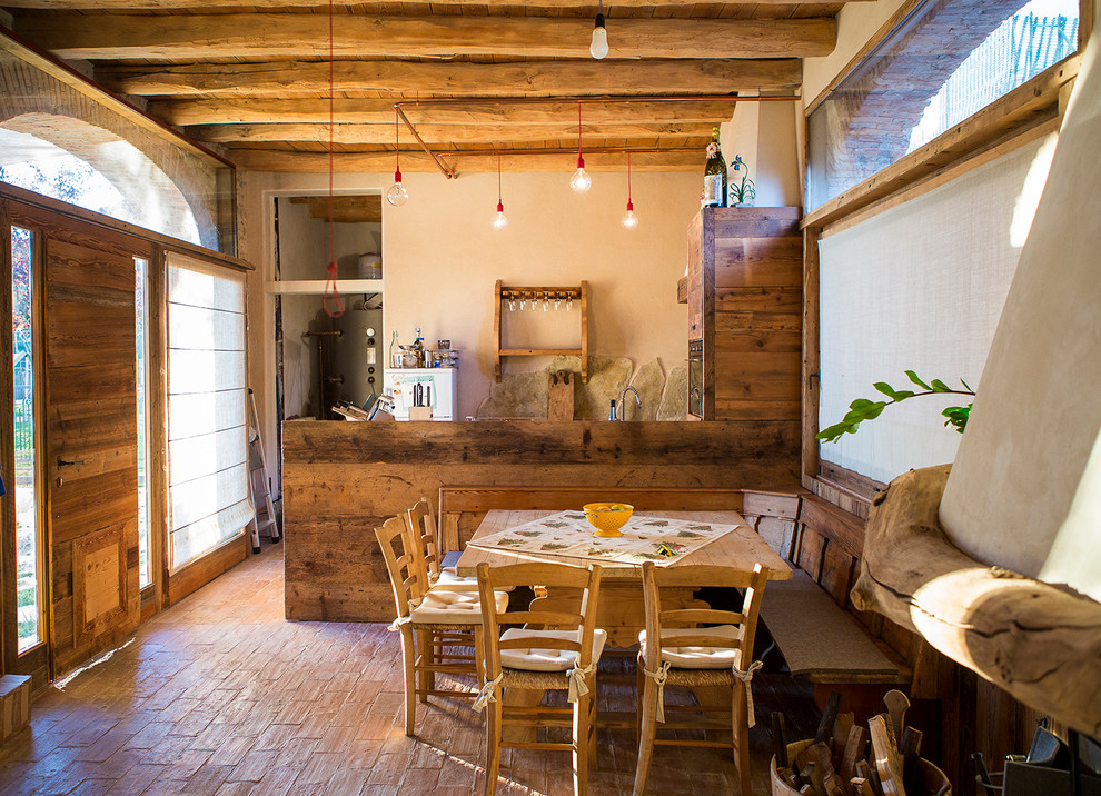 Ejemplo de comedor rural con paredes blancas y suelo de baldosas de terracota