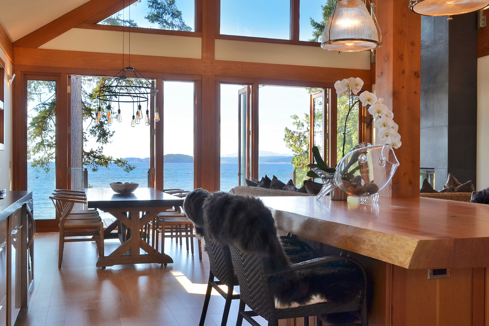 Immagine di una sala da pranzo aperta verso la cucina contemporanea con pareti beige e pavimento in legno massello medio