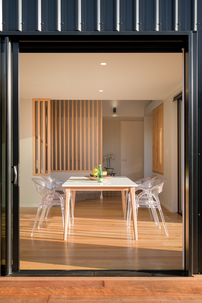 Kleines Modernes Esszimmer mit weißer Wandfarbe, braunem Holzboden und braunem Boden in Christchurch
