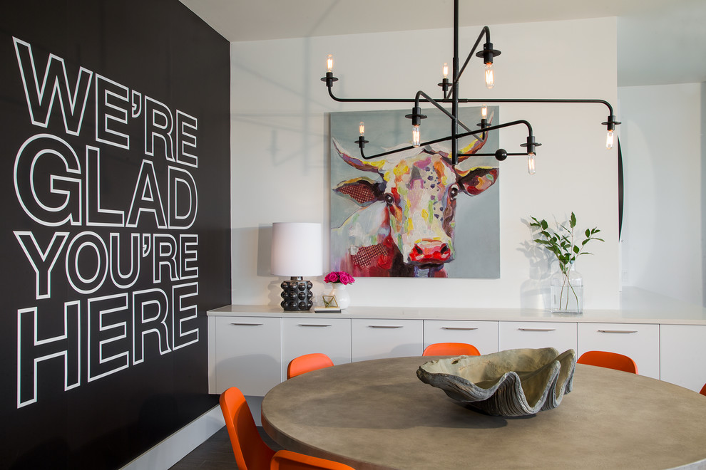 Cette image montre une salle à manger ouverte sur le salon design avec un mur noir, aucune cheminée et éclairage.