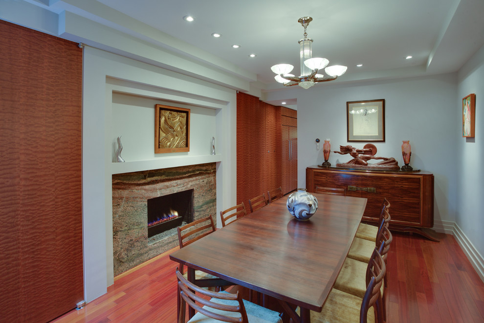 Idee per una sala da pranzo contemporanea chiusa e di medie dimensioni con pareti grigie, parquet scuro, cornice del camino in pietra e camino classico