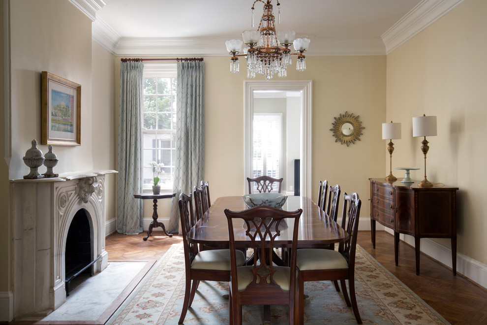 Aménagement d'une salle à manger victorienne fermée avec un mur beige, parquet foncé, une cheminée standard, un manteau de cheminée en béton et un sol marron.