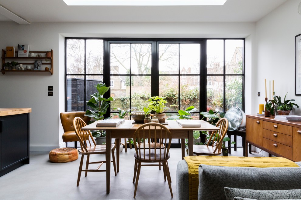 Idee per una sala da pranzo aperta verso il soggiorno contemporanea di medie dimensioni con pareti bianche, pavimento in cemento e pavimento grigio
