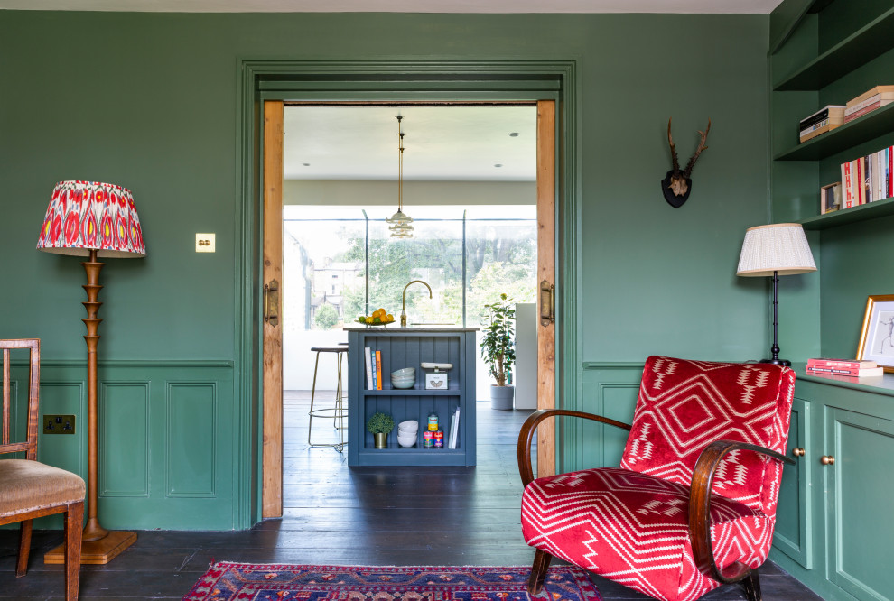 Mittelgroße Klassische Wohnküche mit grüner Wandfarbe, dunklem Holzboden, Kaminofen, Kaminumrandung aus Backstein und braunem Boden in London