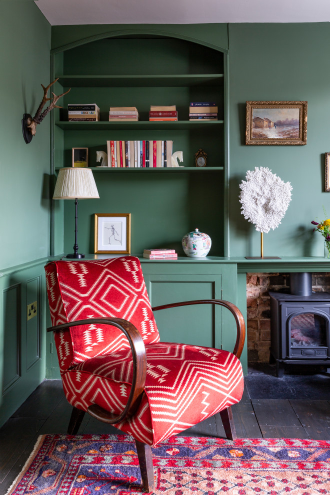 Mittelgroße Stilmix Wohnküche mit grüner Wandfarbe, dunklem Holzboden, Kaminofen, Kaminumrandung aus Backstein und braunem Boden in London