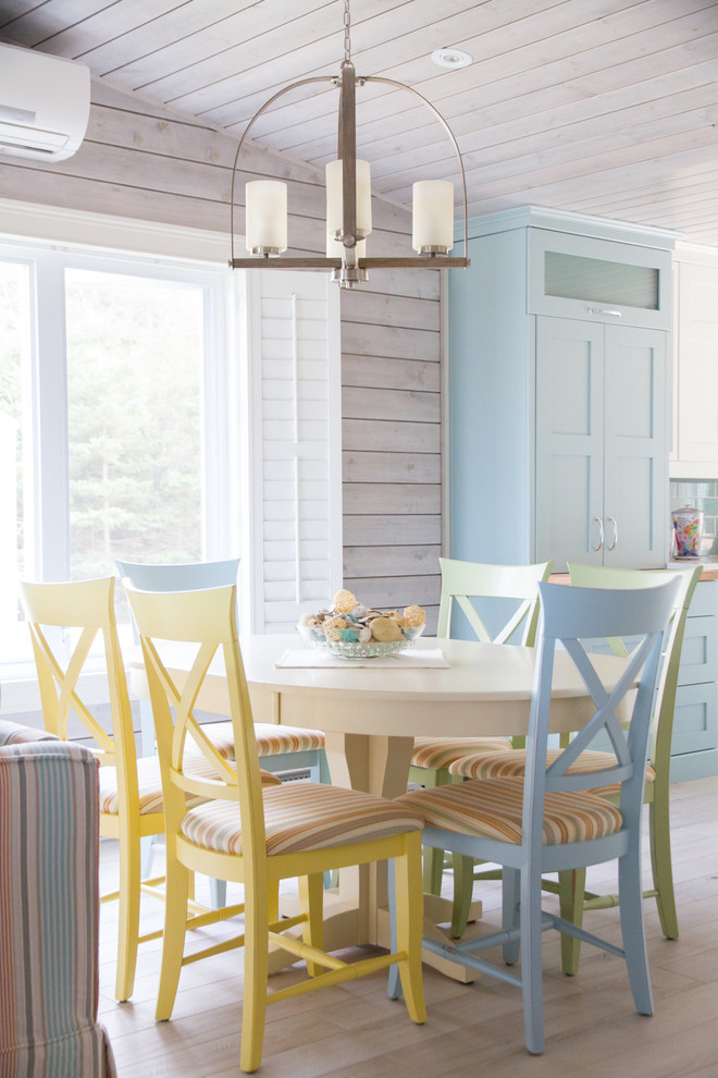 Idee per una sala da pranzo aperta verso il soggiorno stile marinaro con pareti beige, parquet chiaro e pavimento beige