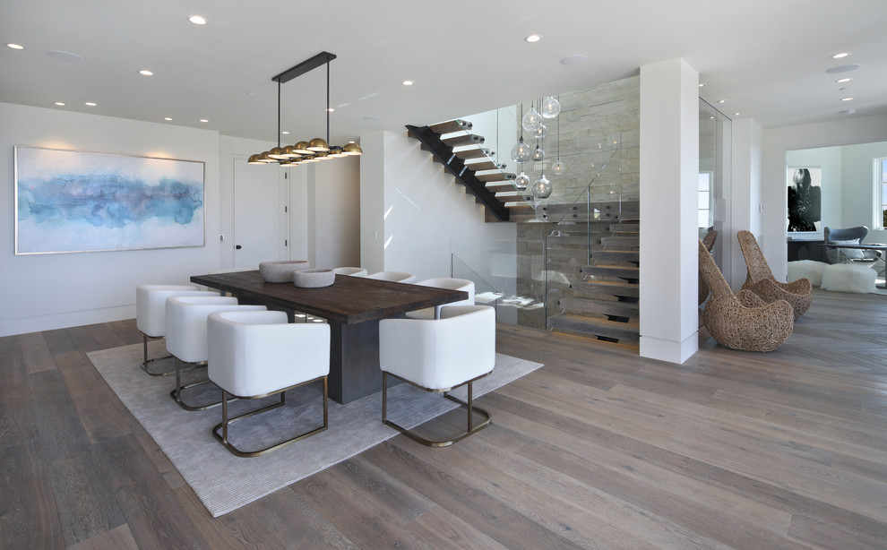 Offenes Modernes Esszimmer mit weißer Wandfarbe, braunem Holzboden und braunem Boden in Los Angeles